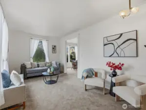 The living room is bright and welcoming. High ceilings add to the spacious feel.