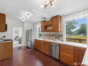 The kitchen is also light and pleasant. It includes a gas range, built-in microwave, tiled counters and backsplash, generous cabinetry and work space.