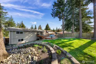 Fully landscaped with easy care plants and flowers. Professional hardscaping defines flower beds for separation and adds elegance to the space