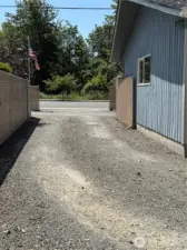 The gravel is allowing the cars and trucks to have less grass to cut and more vehicles to be used and stored with room to spare