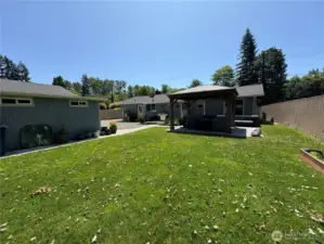 There is a welcoming back yard with a raised flower bed (to right of photo) . See the beautiful Gazebo? The concrete detached blocks will stay if requested (under gazebo)....the large rose quarts rock is personal and will not stay, is property as well as the patio furniture. but you can see how wonderful you can make this your own...