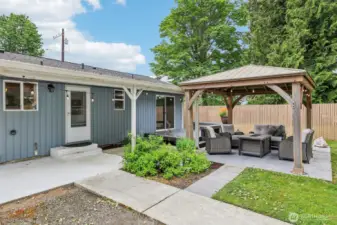There is a welcoming back yard with a raised flower bed (to the right of photo) . See the beautiful Gazebo? The concrete detached blocks will stay if requested (under gazebo)....the large rose quartz rock is personal and will not stay, is property as well as the patio furniture. but you can see how wonderful you can make this your own...