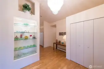 Beautiful display case and chandelier as you enter along with large coat closet