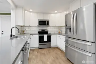 Spacious undermount sink, easy to clean subway tile backsplash and plenty of storage within the white shaker cabinets!