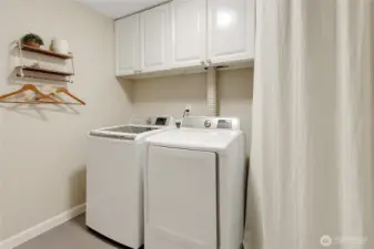 Laundry room has everything you need, storage space, shelves and both washer and dryer convey with the property!