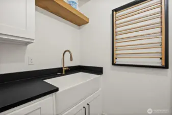 Laundry room has farmhouse sink, granite counters.