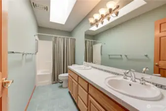Guest bathroom with skylight and double sinks.