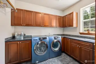 Laundry is a breeze in a lovely room as this! Counterspace for days for folding, crafts, giftwrapping and more. Tile floors let this mud room take the brunt of any messy situations with ease, and the pretty blue washer and dryer are included!