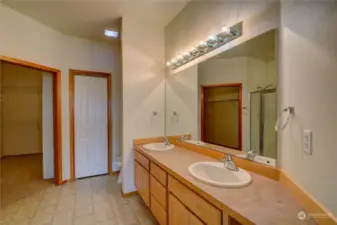 Primary bathroom looking towards walk-in closet. Storage to the right