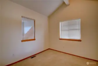 2nd bedroom with window to outdoors and side window overlooking dining area and kitchen