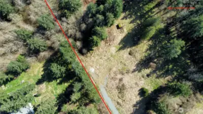 Approximate lot line adjacent to driveway and cleared area