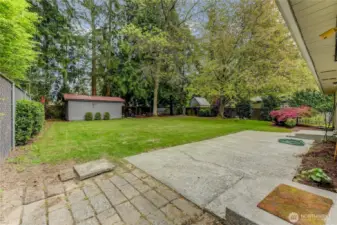 Large back yard with mature landscaping and storage shed.