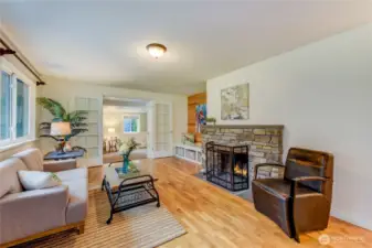Light and bright living room with beautiful hardwood floors and cozy fireplace. French doors lead to a bonus area.