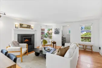 Functional living room with new paint, gas fireplace, hardwood floors and natural light pouring in.