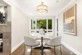 West-facing dining room with large windows that flood the space with natural light, even on the ground floor. A modern light fixture and open flow to the kitchen and living room make this a warm and welcoming spot to gather.