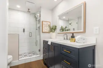 The spa-inspired shower includes multiple showerheads, custom tile work, and a built-in bench—designed for everyday indulgence.