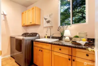 Large laundry features cabinetry, deep utility sink , bulilt-in storage.