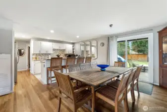 Dining Room -   Spacious dining area with hardwood floors, breakfast bar seating, and sliding door access to the backyard patio.