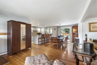 Welcoming interior entry view with beautiful hardwood floors and open sightlines into the dining area and updated kitchen.