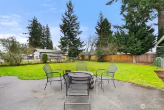 Back patio is ready for outdoor dining, relaxing, and entertaining with a wide-open backyard backdrop.