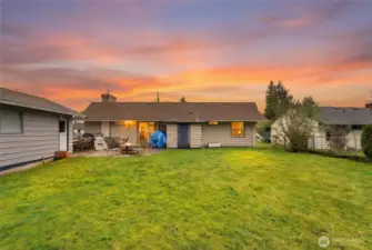 Rear exterior view highlights the expansive backyard, patio space, and easy access to outdoor living.