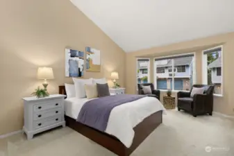 Primary bedroom features bay window and vaulted ceilings.