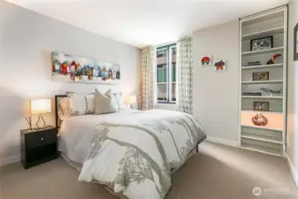 Lovely guest space with built-in shelving and new carpeting.