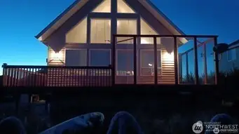 Night view of home and outside sitting area protected from wind