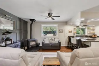 Just off the kitchen, an additional family room featuring a wood-burning stove and an artistically styled accent wall offers a warm, inviting space that naturally draws guests in for conversation and entertaining.
