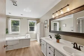 The ensuite primary bathroom features a large soaking tub, separate shower, and double vanity, along with extra built-in storage for linens and toiletries.