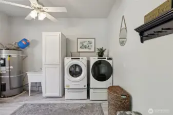 The laundry room has storage, utility sink and the water heater for easy access.
