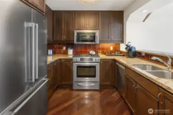 Kitchen with vaulted ceilings, large firdge, gas cooktop.