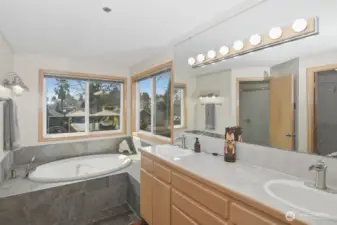 Primary bathroom with jetted tub, double sinks, and walk in shower.