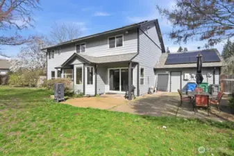 Fenced backyard with covered patio and garden space.