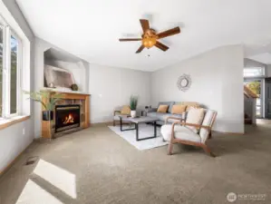 Here's one view of the living room with fireplace and ceiling fan a peek at the entry and stairs on the far right of the photo.