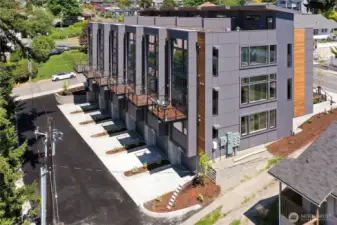 View of the back with parking garage, small decks off the main level.