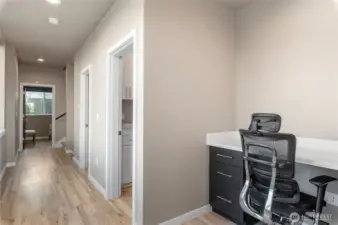 Lower level hallway to additional two bedrooms, laundry room and full bath with small office nook.