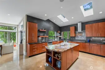 This statement kitchen is a work of art - showcasing sleep custom cabinetry, a stunning live edge granite island, full-height tile backsplash, and skylights that invite the natural light and forest canopy in.
