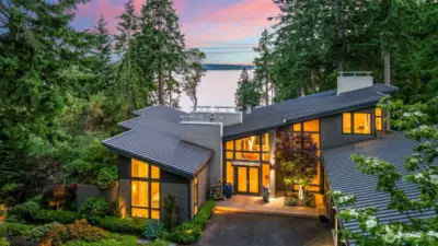 Bold rooflines, walls of glass, and intentional design define this elevated modern home overlooking the Sound. Perched above the shoreline, it blends structural elegance with the serenity of its Fox Island setting.