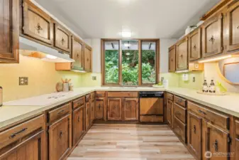 Expansive cabinetry lines this beautiful kitchen, with every detail designed for convenience and a charming window nook that adds light and character.