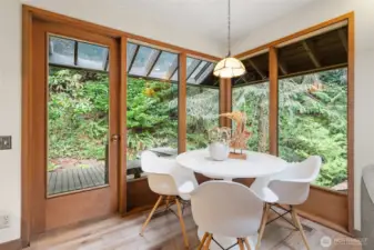 Staged as a family room with an eating nook, this versatile flex space off the kitchen offers room to relax, work, or gather—plus access to a private deck.
