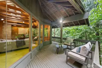Covered portions of the expansive deck offer year-round enjoyment, creating a private retreat embraced by lush greenery.