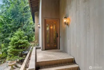 Elegant front entry framed with timeless brick steps and lantern lighting, setting a warm and sophisticated welcome into the home.