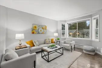 Beautiful laminate flooring extends through the main living areas, complemented by expansive picture windows that bathe the interior in warm, natural light.