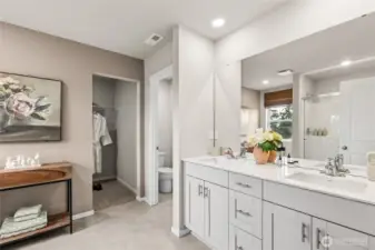 Primary bath with step in shower and double vanity with quartz countertops. Photo is representational. Actual home is under construction. Colors, materials, and features may vary. See site agent for details.