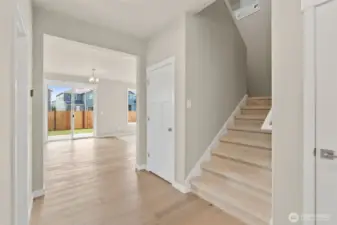 Coat closet with extra storage underneath the stairway.