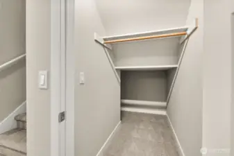 Coat closet with extra storage underneath the stairway.