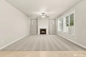 Spacious and inviting great room with a clean, modern design and gas fireplace including a ceiling fan.