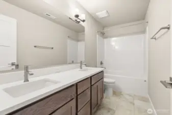 Main bathroom with dual sink vanity and quartz countertops.