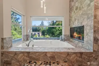 Totally custom stone features around the jetted soaking tub surrounded by windows.